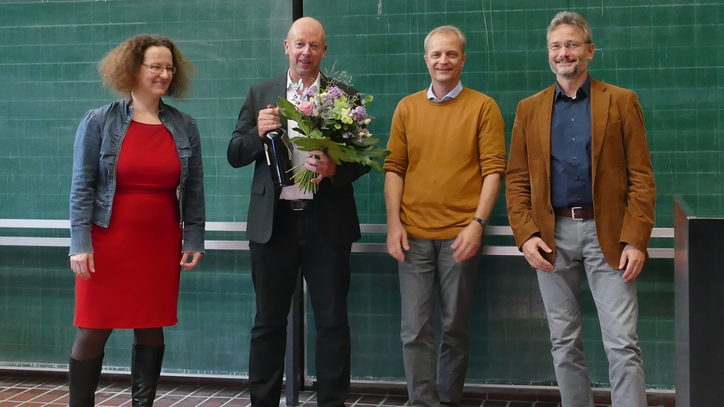 Scheidender Dekan mit Blumenstrauß in Gruppe mit 2 Professoren des Vorstands und Geschäftsführerin