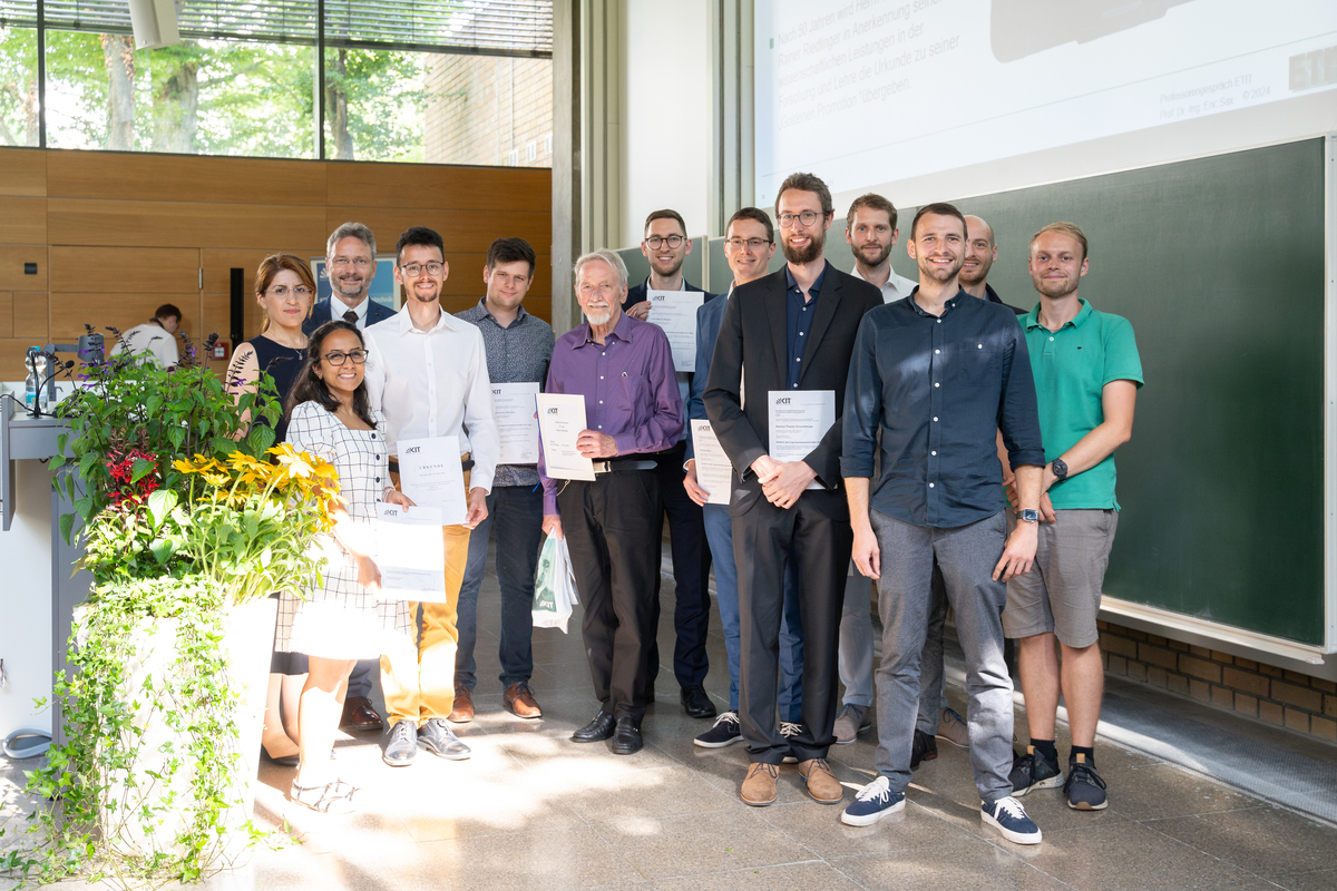 Gruppenbild mit Blumenschmuck: Promovierte, Goldener Promovierter und Dekan Prof. Sax